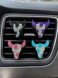 Hollow Creek Longhorn vent clips in black, purple, pink, and teal on a car vent